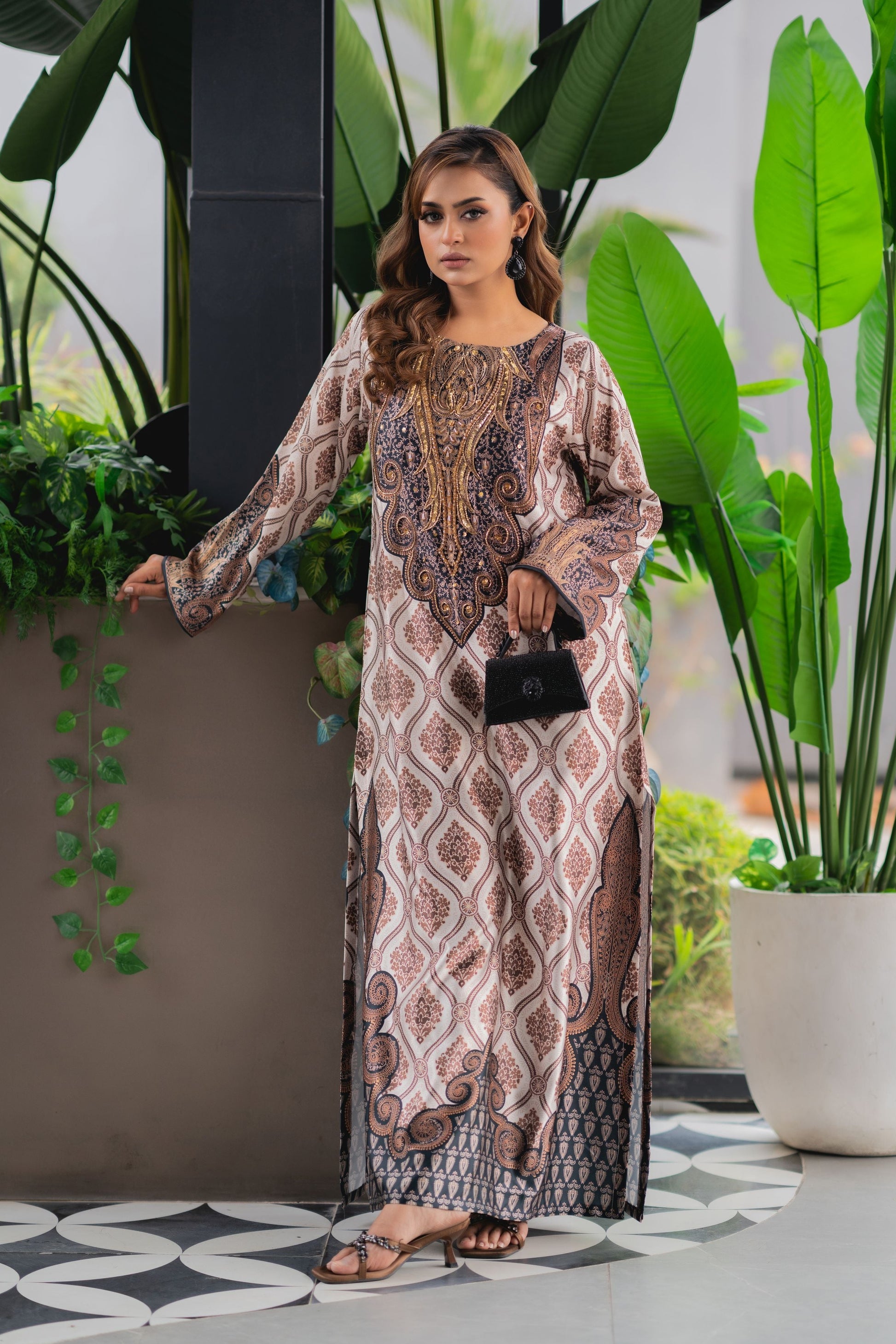 Woman in a patterned dress standing in a room with plants