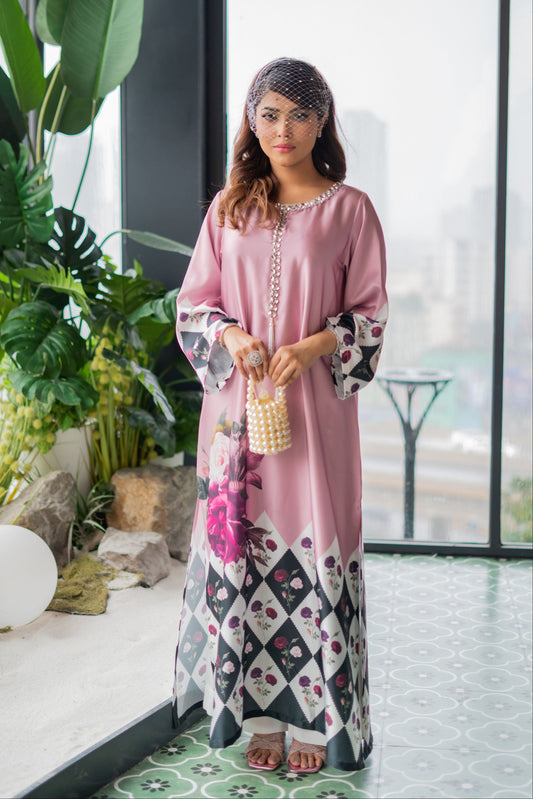 Woman in a pink and patterned dress holding a pearl-handled bag indoors.